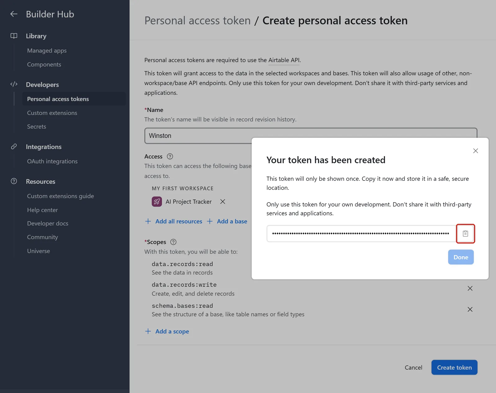 Airtable's dialog headed Your token has been created, saying the token will only be shown once, with the token hidden and its copy button outlined; behind it the form lists one base and the scopes data.records:read, data.records:write and schema.bases:read